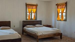 Posada San Lázaro في Choluteca: سريرين في غرفة بها نافذتين