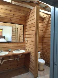 uma casa de banho em madeira com 2 lavatórios e um WC. em Posada San Lázaro em Choluteca