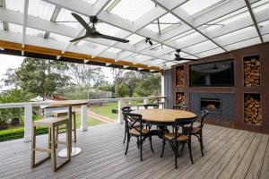 a screened porch with a table and chairs and a tv at Kalinya Estate Platinum- Homestead, Lodge & Barn- up to 34 guests in Bargo