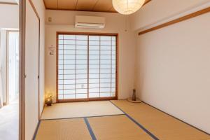 um quarto vazio com uma grande janela e uma porta em Universal Bay Condominium em Osaka