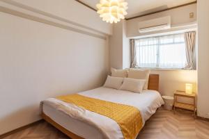 1 dormitorio con cama y ventana en Universal Bay Condominium en Osaka