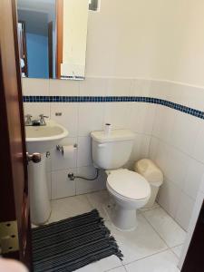 a bathroom with a toilet and a sink at Hermoso y cómodo loft con vista a los nevados in Riobamba