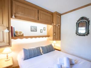 Schlafzimmer mit einem weißen Bett und Holzschränken in der Unterkunft Appartement Chamonix-Mont-Blanc, 3 pièces, 4 personnes - FR-1-343-167 in Chamonix-Mont-Blanc