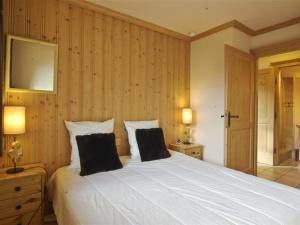 um quarto com uma grande cama branca e 2 almofadas em Appartement Chamonix-Mont-Blanc, 3 pièces, 6 personnes - FR-1-343-168 em Chamonix-Mont-Blanc