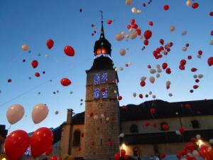 a group of balloons flying in the air next to a building at Hôtel et appart'hôtel de l'Hermitage in Thônes