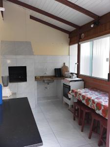 a kitchen with a table and a counter in it at APT Praia Central Itapema 90MTS do Mar in Itapema