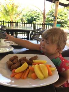 a child sitting at a table with a plate of food at Anveela in Beruwala