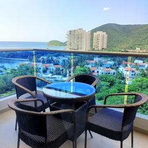 balcón con mesa, sillas y vistas en Samaria - Apartamento en Club de Playa, Santa Marta, en Santa Marta