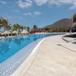 a swimming pool at a resort with a mountain in the background at Samaria - Apartamento en Club de Playa, Santa Marta in Santa Marta