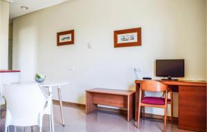 a room with a desk and a tv and chairs at Awesome Apartment In Bolnuevo With 1 Bedrooms, Wifi And Outdoor Swimming Pool in Bolnuevo