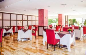 a dining room with tables and red chairs at Awesome Apartment In Bolnuevo With 1 Bedrooms, Wifi And Outdoor Swimming Pool in Bolnuevo