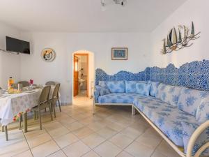 a living room with a blue couch and a table at Pleasant apartment in Aglientu with shared pool in Aglientu