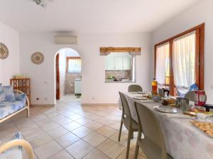 a living room with a table and chairs and a room at Pleasant apartment in Aglientu with shared pool in Aglientu