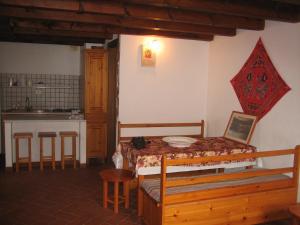 ゴンネーザにあるCasa Luciaのベッド、テーブル、キッチンが備わる客室です。