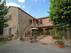 a building with a courtyard with potted plants at Agriturismo L' Agresto in Casole dʼElsa