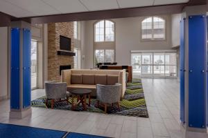 a lobby with a couch and chairs and a fireplace at Holiday Inn Express & Suites Asheville SW - Outlet Ctr Area, an IHG Hotel in Asheville