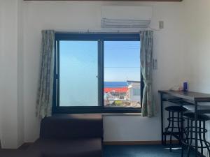 una ventana con vistas al océano desde una habitación en ゲストハウスKOIZUMI en Oshima