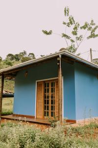 a blue house with a window at Sítio do Filipe na Cachoeira do Tabuleiro in Conceição do Mato Dentro