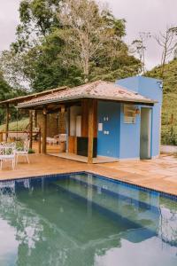 a house with a swimming pool in front of a house at Sítio do Filipe na Cachoeira do Tabuleiro in Conceição do Mato Dentro