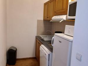małą kuchnię z białą lodówką i kuchenką mikrofalową. w obiekcie Appartement spacieux à 300m des pistes et commerces avec balcon, parking - FR-1-618-21 w mieście Albiez-Montrond