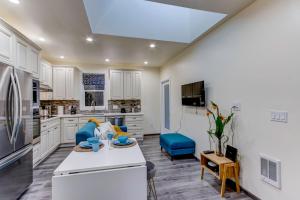 a large kitchen with white cabinets and a blue chair at Marbella Lane - Bright and Cozy Home near SFO in San Mateo