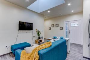 a living room with a blue couch and a tv at Marbella Lane - Bright and Cozy Home near SFO in San Mateo