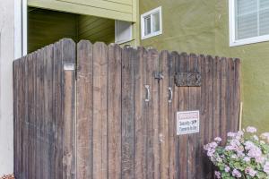 a wooden fence in front of a house with a no trespassing sign at Marbella Lane - Bright and Cozy Home near SFO in San Mateo