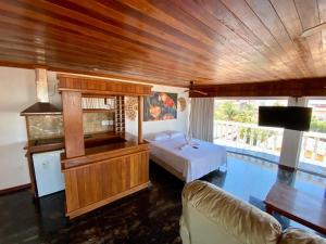a bedroom with a bed and a television and a pool at Canoa Suites & Apartments in Canoa Quebrada