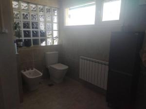 a bathroom with a toilet and a sink and a window at Dto Lenore.Esquel con la mejor vista a la montaña! in Esquel