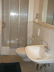 a bathroom with a shower and a toilet and a sink at Hotel Messe am Funkturm in Berlin