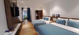 een hotelkamer met twee bedden en een flatscreen-tv bij Ánh Dương House in Da Lat