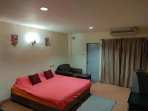 Nong PrueにあるThai Smile serviced Appartmentsのベッドルーム(赤いベッド1台、椅子付)