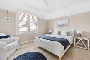 a white bedroom with a bed and a couch at Best location in Manly Harbour view in Sydney