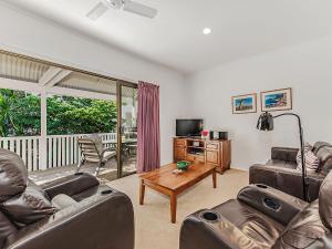 a living room with two leather couches and a table at Unit 2 Riverbreeze in Noosaville