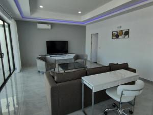 - un salon avec un canapé et une télévision dans l'établissement PATTAYA POOL VILLA 427 nearby WALKING STREET, à Pattaya (sud)