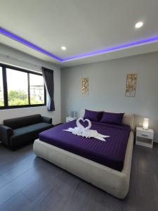- une chambre dotée d'un grand lit violet avec un cygne dans l'établissement PATTAYA POOL VILLA 427 nearby WALKING STREET, à Pattaya (sud)