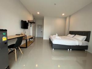 a hotel room with a bed and a desk and a desk at Life Hotel Rong Khun in Ban Mai