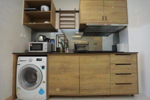 a kitchen with a washing machine and a washer at SarangSinggah@Timurbay Seafront in Kuantan
