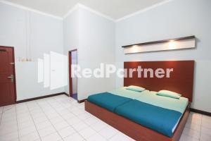 En eller flere senge i et værelse på Hotel Mexicanna Syariah Mitra RedDoorz