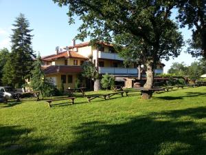 un parc avec des bancs et un arbre devant un bâtiment dans l'établissement Туристически комплекс"Странджа", à Sredets