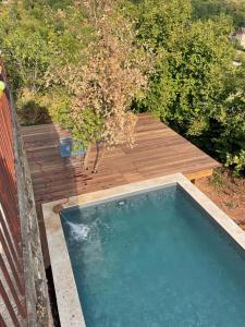 - une piscine avec une terrasse en bois à côté dans l'établissement holiday home Chateau Castelnau, à Prudhomat