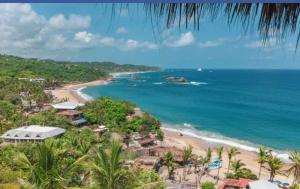 a beach with palm trees and palm trees at Ivanna hostel mazunte in Mazunte