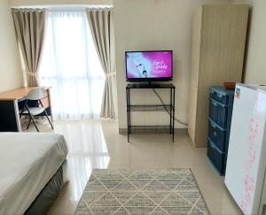 - un salon avec une télévision et un lit dans l'établissement Tmn Melati Margonda-Relaxed and Friendly, à Pondokcina