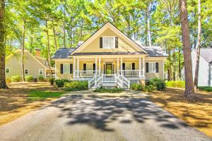a large yellow house with a driveway at Stunning Lake Oconee Retreat with Pool Access! in Turnwold