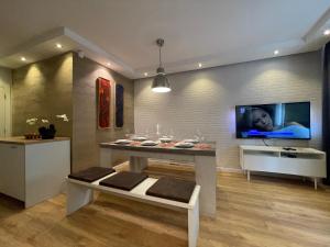 a dining room with a table and a tv on the wall at Luxury Apartments In Top City Center Varna 2 in Varna City