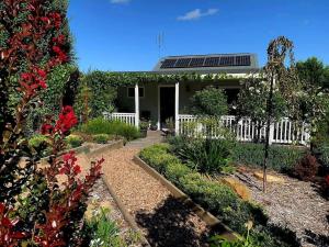 ein Haus mit einem weißen Zaun und einem Garten in der Unterkunft Hidden Gem ~ Luxury Cottage near Lake Daylesford in Daylesford