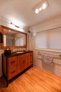 ein Bad mit einem Waschbecken und einem Spiegel in der Unterkunft Hidden Gem ~ Luxury Cottage near Lake Daylesford in Daylesford