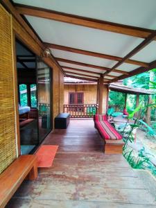 a screened in porch of a house with benches and tables at Phoxay Ngam Resort in Vang Vieng