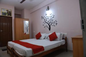 Collection O Safe Hotel Kadavanthra في إرناكولام: غرفة نوم مع سرير مع ملصق شجرة على الحائط