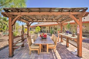 a wooden pergola with a wooden table and chairs at Dreamy Desert Studio with Deck and Pool Access! in Phoenix